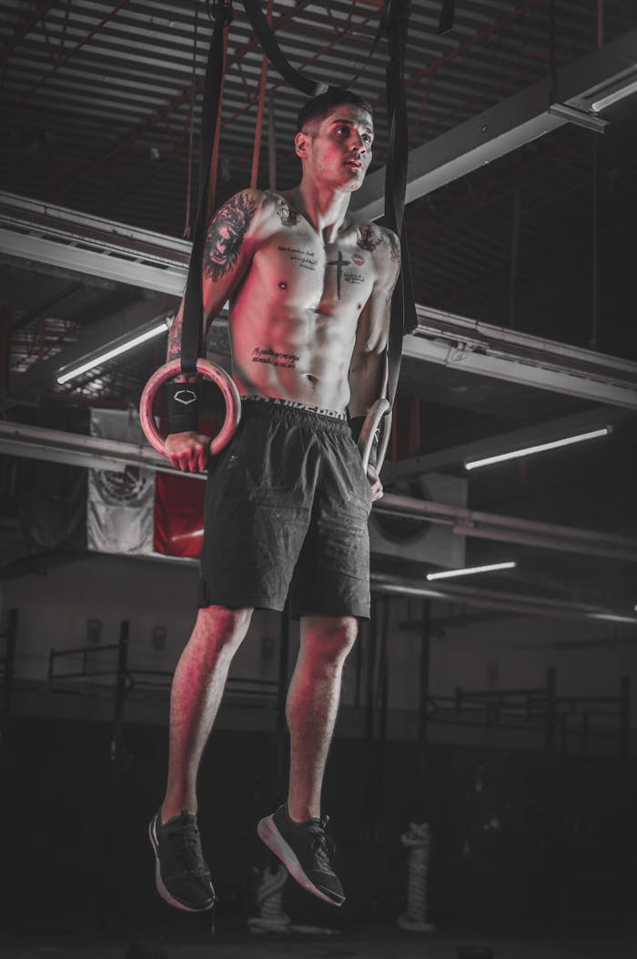 Athlete performing strength training on rings indoors in Ciudad Juárez gym.